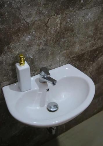 a white bathroom sink with a soap dispenser on it at Villa Panderman Batu Malang in Batu