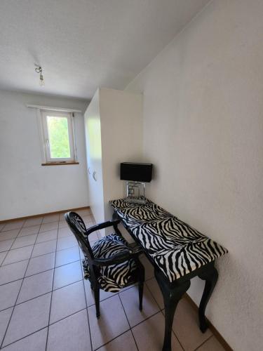 a room with a table and a zebra print chair at La Villa Joly - Avenches in Avenches
