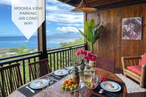 a table with food on a balcony with a view of the ocean at Taapuna SunSet Moorea View in Atiue