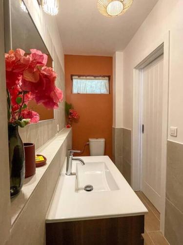 a bathroom with a sink and a vase of flowers at Taapuna SunSet Moorea View in Atiue