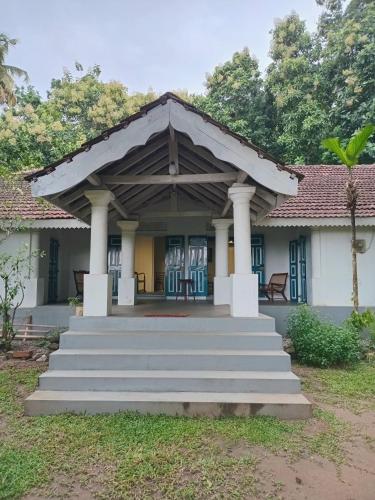 a house with a porch and stairs in front at Lekham Walauwa in Matale