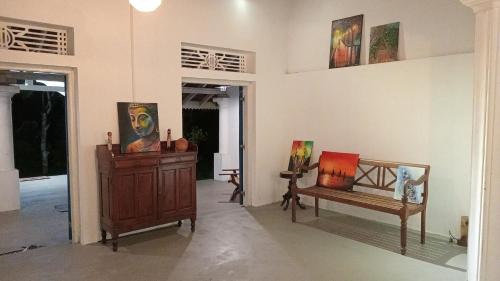 a room with two chairs and paintings on the wall at Lekham Walauwa in Matale