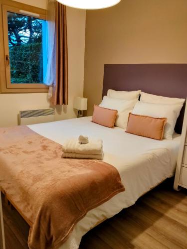 une chambre avec un grand lit blanc avec deux oreillers dans l'établissement Ravissant Cottage avec jardin, refait à neuf, 2 à 5 pers, à Cabourg