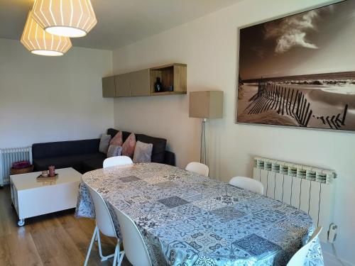 un salon avec une table et un canapé dans l'établissement Ravissant Cottage avec jardin, refait à neuf, 2 à 5 pers, à Cabourg