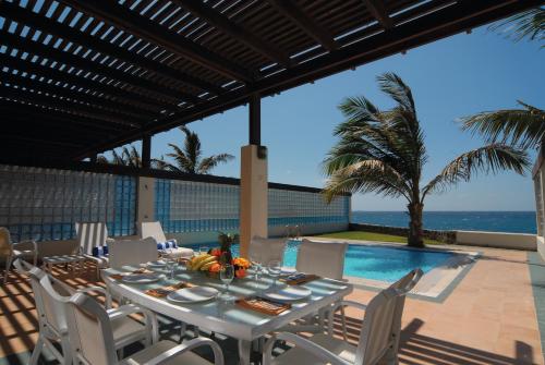 ein Esszimmer mit einem Tisch, Stühlen und Meerblick in der Unterkunft Mövenpick Al Nawras Jeddah - Family Resort in Dschidda