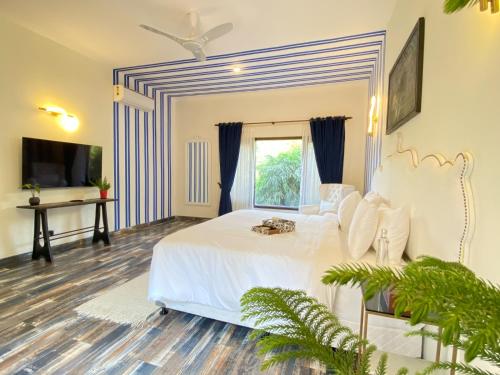 a bedroom with a white bed and a window at Karma Lakelands Golf Resort & Residences in Gurgaon