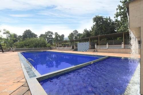 a large blue swimming pool with a water fountain at The Retreat by City Homes Aashiyaanaa in Jambhulpāda