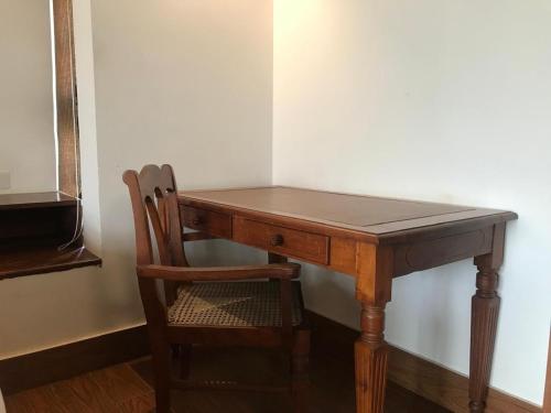 a wooden desk with a chair next to a wall at Capital Wind Beach Cabanas in Kalpitiya