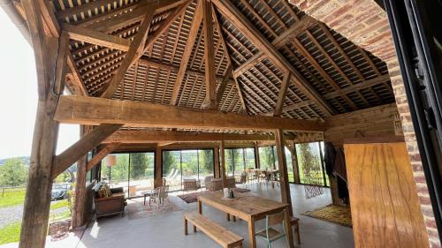 a large room with a wooden table in a building at Le Domaine de Blanvatel in Sainte-Marguerite-de-Viette