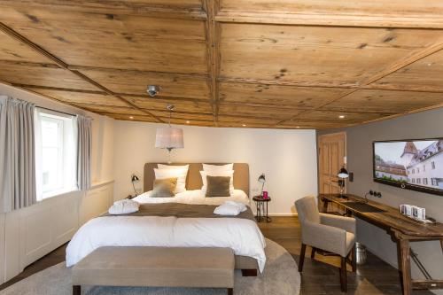 a bedroom with a large bed and a wooden ceiling at Boutique - Hotel Adara in Lindau