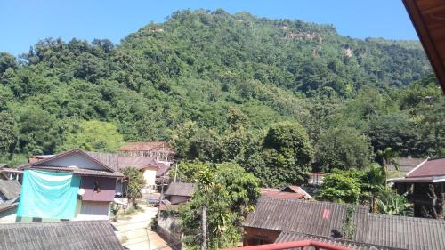 a village with a mountain in the background at Amphai Guest house in Nongkhiaw