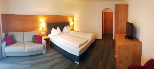 a hotel room with a bed and a chair at Wander- und Familienhotel Erika in Wagrain