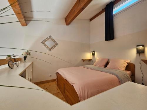 une petite chambre avec un lit et une fenêtre dans l'établissement Gîte Lo Becarut L'Escapade Des Flamants Roses, à Mireval