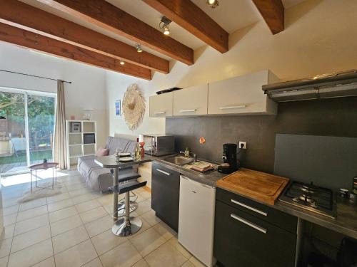 une cuisine et un salon avec un canapé dans l'établissement Gîte Lo Becarut L'Escapade Des Flamants Roses, à Mireval