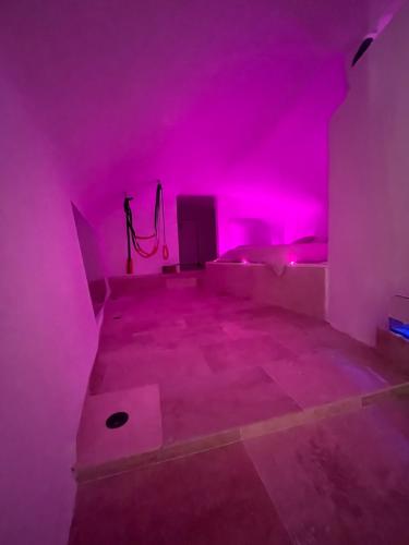 une chambre avec des lumières roses au sol dans l'établissement Grotte love, à Pierrefeu-du-Var