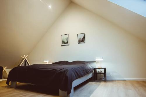 a bedroom with a bed and two pictures on the wall at Lichtrijke woning aan het Muziekbos in Ronse