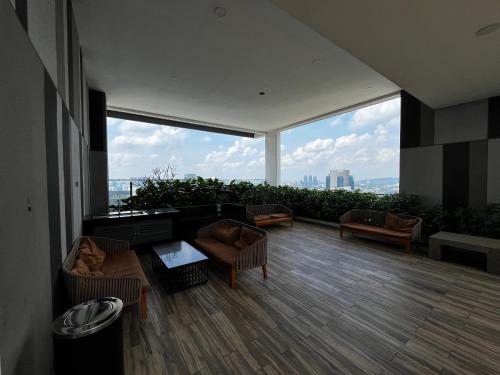 - un salon avec des canapés et des chaises ainsi qu'une grande fenêtre dans l'établissement THE COLONY INFINITUM Sweet Home SR, à Kuala Lumpur