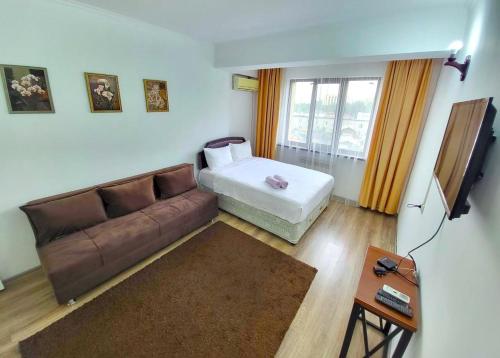 a living room with a couch and a bed at Appartments " Zhetysu-4" in Almaty