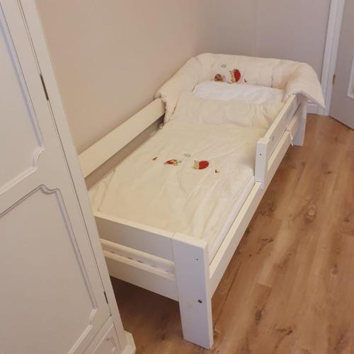a small white bed with a teddy bear on it at Dom całoroczny nad Bugiem in Wasilew Szlachecki