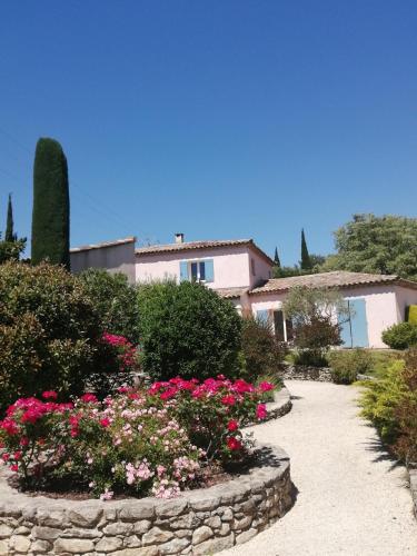 une maison avec un jardin de fleurs et de buissons dans l'établissement Villa l'Hestia avec piscine à l'Isle-sur-Sorgue, à LʼIsle-sur-la-Sorgue