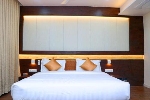 a large white bed with a large screen above it at THE GRAND ASTORIA SOMANTH by Shivalaya Darshanam in Somnath
