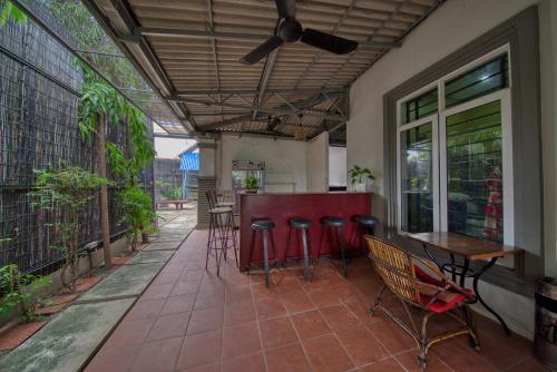 a patio with a bar with chairs and tables at Kalinga Art Home Guest House in Siem Reap
