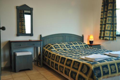 sypialnia z łóżkiem, stołem i lustrem w obiekcie Palm Court Suites w mieście Ayvalık