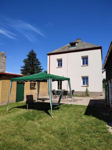a green tent in the grass in front of a building at Apartmány Hvězdecká in Broumov