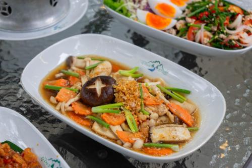 a bowl of soup with vegetables and other foods at Puprai Tarnnarm Resort in Thong Pha Phum