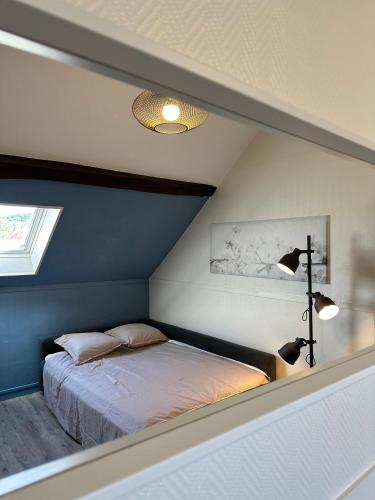 une chambre avec un lit avec un mur bleu dans l'établissement Le confort à 2 pas de la gare, à Sens