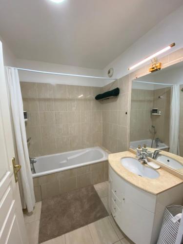 une salle de bain avec un lavabo et une baignoire dans l'établissement Le Grand Palais de la Méditerranée Beach Access Apartments - Top Choice In Nice, à Nice