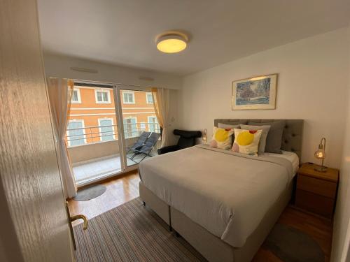 une chambre avec un lit et une grande fenêtre dans l'établissement Le Grand Palais de la Méditerranée Beach Access Apartments - Top Choice In Nice, à Nice