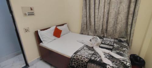uma pequena cama com toalhas num quarto em JPM GUEST HOUSE em Varanasi