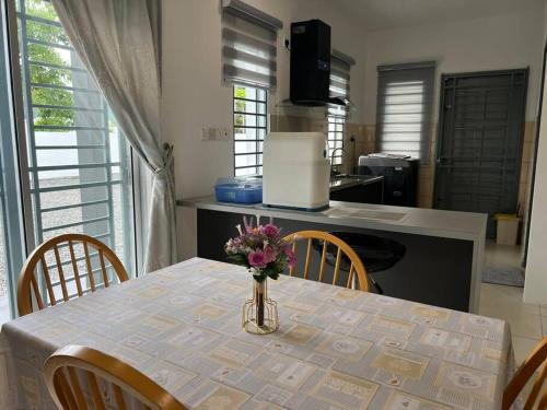 a vase of flowers on a table in a kitchen at Essential Homestay in Tawau - Bandar Sri Indah in Kampong Parit