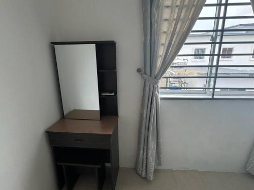 a mirror and a dresser in a room with a window at Essential Homestay in Tawau - Bandar Sri Indah in Kampong Parit