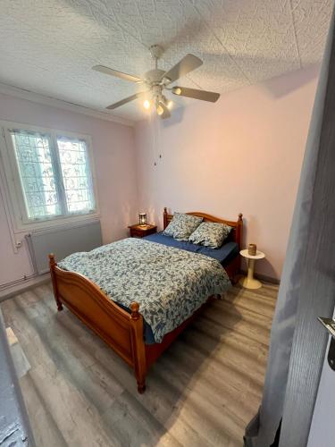une chambre avec un lit et un ventilateur de plafond dans l'établissement Maison de vacance Valras-Plage, à Valras-Plage