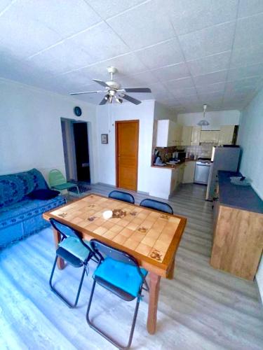 un salon avec une table et des chaises en bois dans l'établissement Maison de vacance Valras-Plage, à Valras-Plage