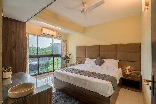 une chambre avec un grand lit avec une grande fenêtre dans l'établissement Idyllic Abode 2 bhk apartment, à Goa