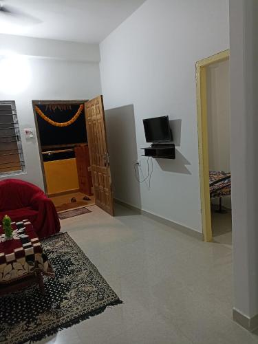 a room with a living room with a tv and a couch at Skd heights in Silchar