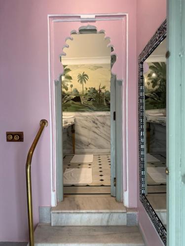 a hallway with a mirror in a pink house at Amet Haveli - A Heritage Hotel Udaipur in Udaipur