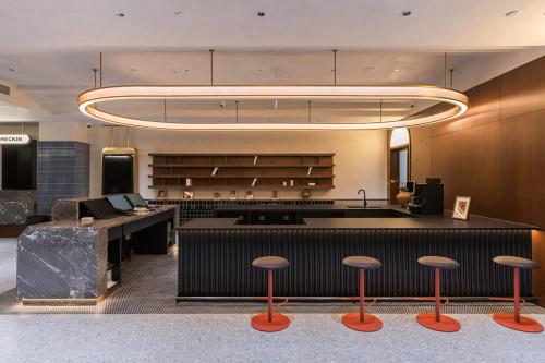 a lobby with a counter and stools in a room at Suisse Place Beijing Jinsong Subway Station in Beijing
