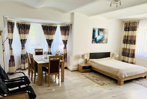 a bedroom with a bed and a table and chairs at Spa Park Guest Rooms in Długopole-Zdrój
