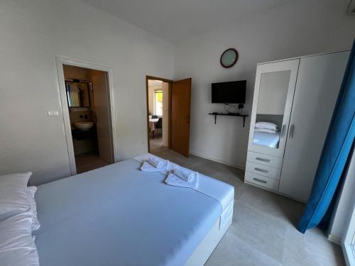 a bedroom with a white bed and a tv at Pansion Palme in Drvenik