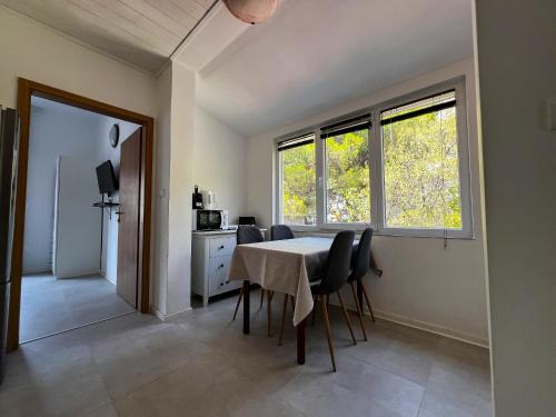 a dining room with a table and chairs and a window at Pansion Palme in Drvenik