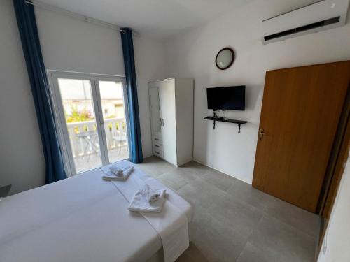 a bedroom with a bed with a mirror and a tv at Pansion Palme in Drvenik