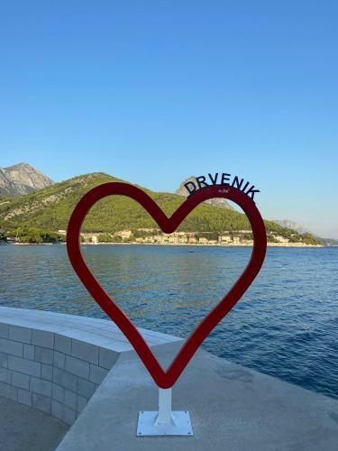a heart statue in front of a body of water at Pansion Palme in Drvenik