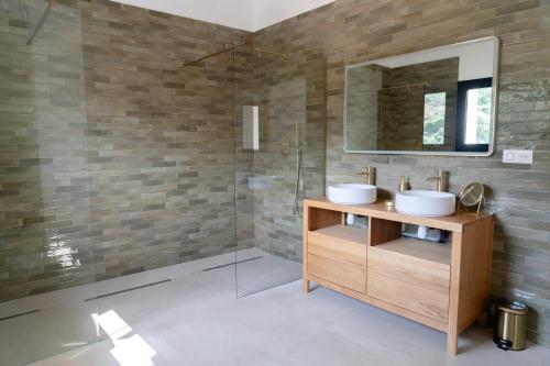 une salle de bain avec deux lavabos et un miroir dans l'établissement Le Mas d'Antonegre, demeure d'exception, sud de France, à Montbazin