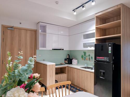 a kitchen with a black refrigerator and a table at MIA HOMESTAY 2PN2WC cạnh Aeon Tân Phú in Ho Chi Minh City