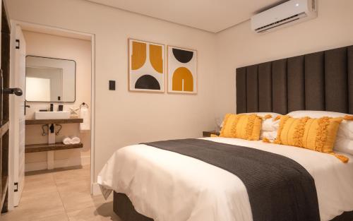 a bedroom with a large bed and a sink at Beach Wood Boutique Hotel & Resort in Ballito