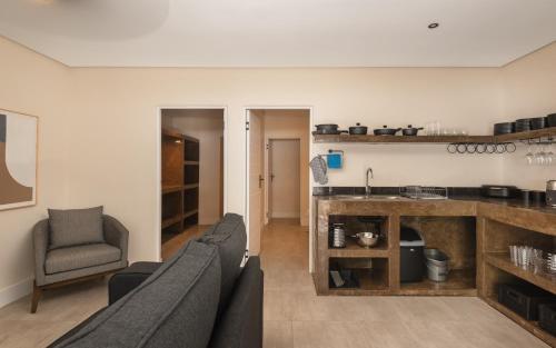 a living room with a couch and a kitchen at Beach Wood Boutique Hotel & Resort in Ballito